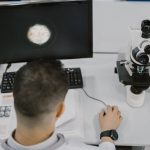 Cientista trabalha com um microscópio em um laboratório moderno.
