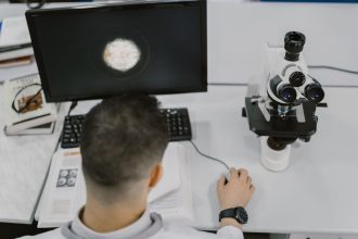 Cientista trabalha com um microscópio em um laboratório moderno.