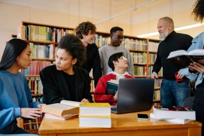 Estudantes de diferentes origens conversam e estudam juntos em uma biblioteca universitária.